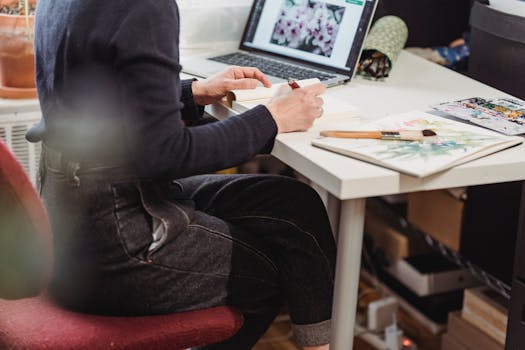 a creative workspace with a sketchbook and plants